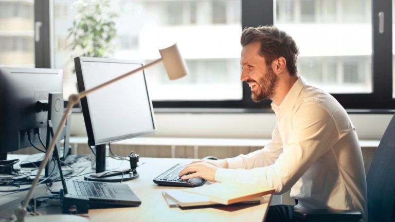 Man smiling while on computer